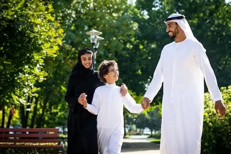  Cha mẹ nắm tay con nhỏ đi dạo trong khu vui chơi an toàn ở Dubai