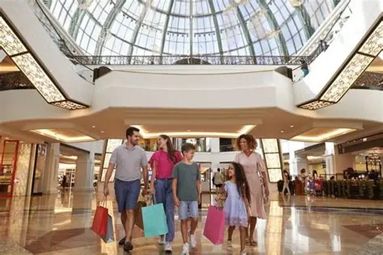 Gia đình nhiều thế hệ mặc trang phục thoải mái tham quan trung tâm thương mại Dubai Mall