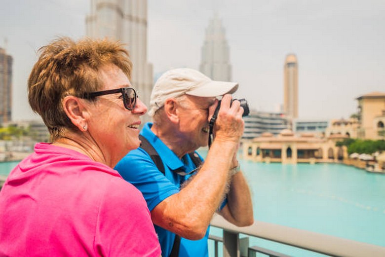 Du khách lớn tuổi thong thả tham quan ngoài trời ở Dubai Marina vào mùa mát
