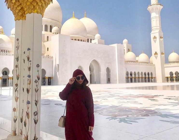 Nữ du khách mặc áo choàng và khăn choàng khi tham quan Đại Thánh Đường Sheikh Zayed