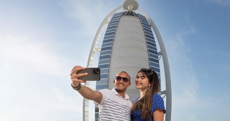 Khách du lịch chụp ảnh trước một khách sạn tại Dubai trước khi khởi hành tham quan Abu Dhabi